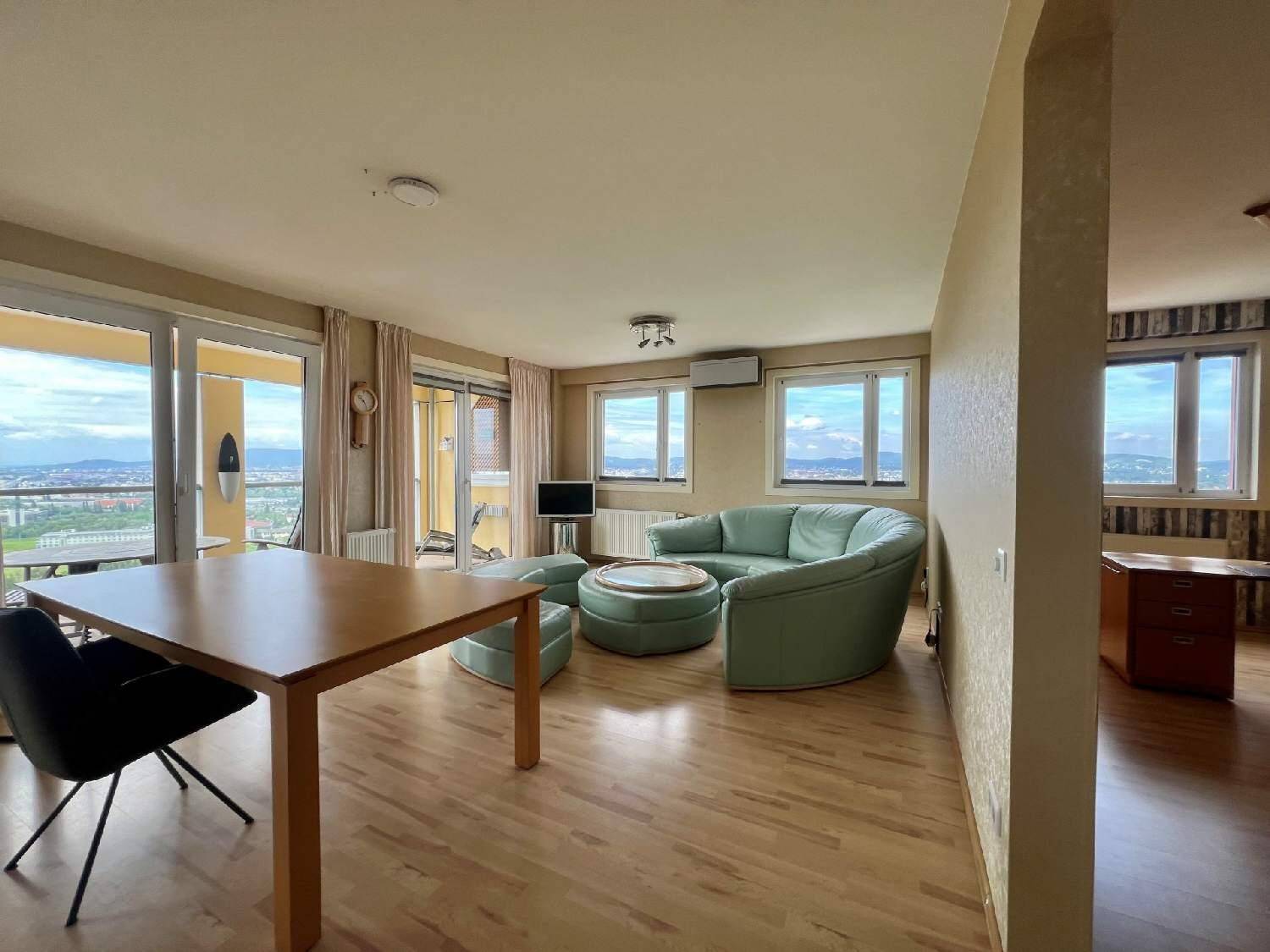 Heller Wohn- und Essbereich mit Holzboden, bequemen Sitzmöbeln und Zugang zu einem Balkon mit Aussicht.