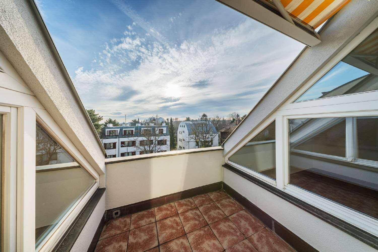 Dachbalkon mit Fliesenboden, Markise und weitem Blick über die umliegende Nachbarschaft und Dächer.