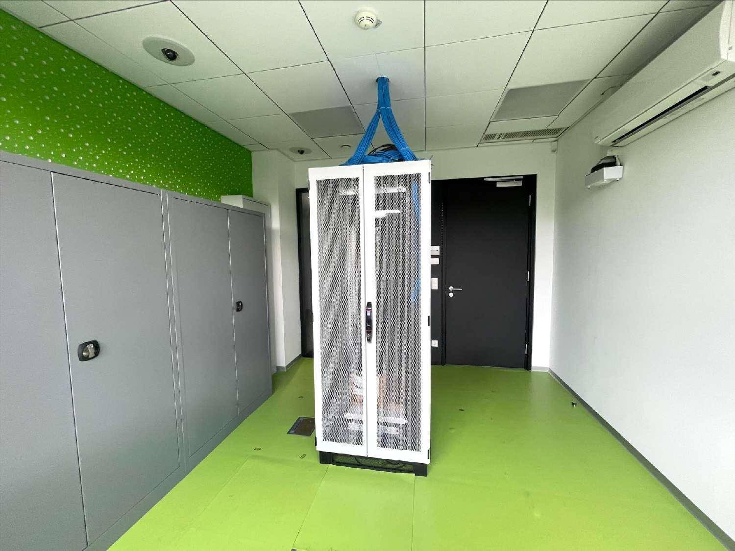 Serverraum mit grüner Wand, Schränken und Klimaanlage.