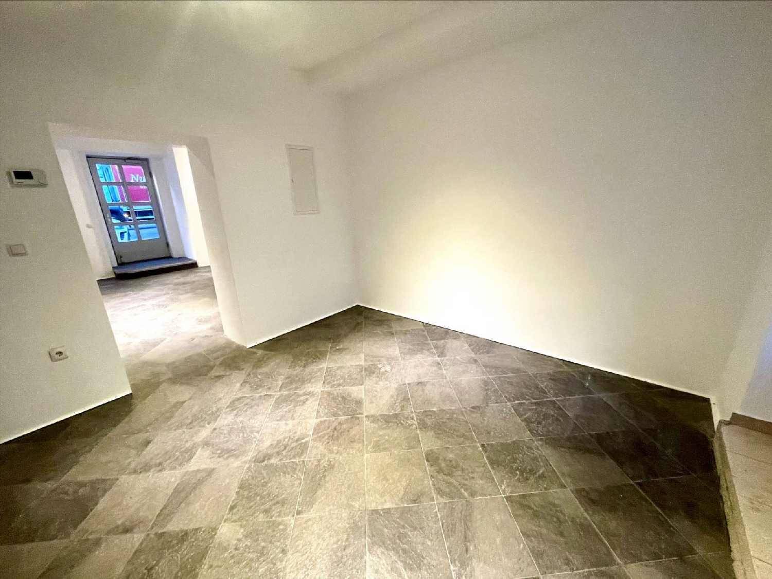 Heller Eckbereich eines Geschäftsraums mit Fliesenboden und weiß gestrichenen Wänden.