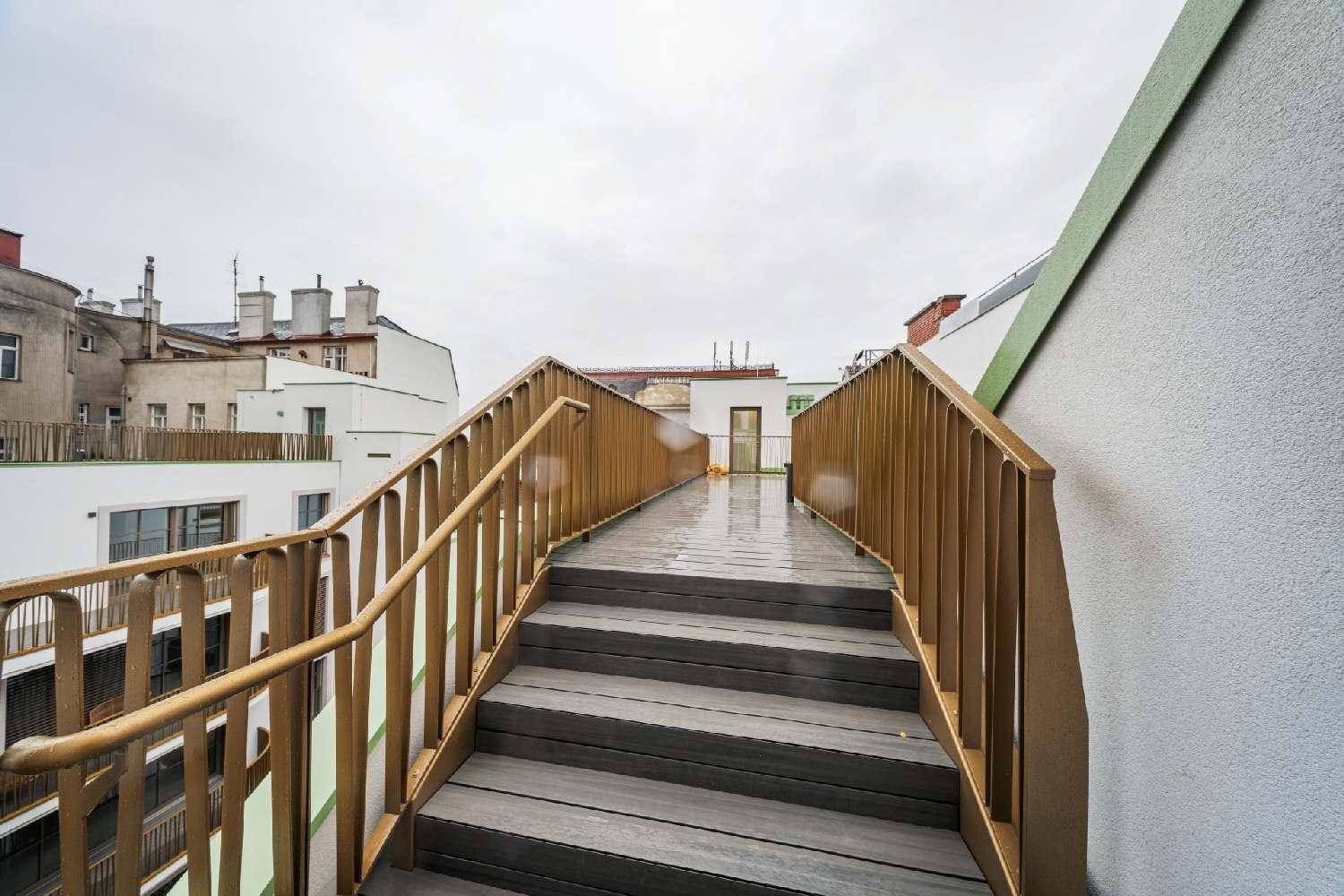 Moderner Zugang zur Dachterrasse mit eleganten Geländern und Blick auf die Stadt.