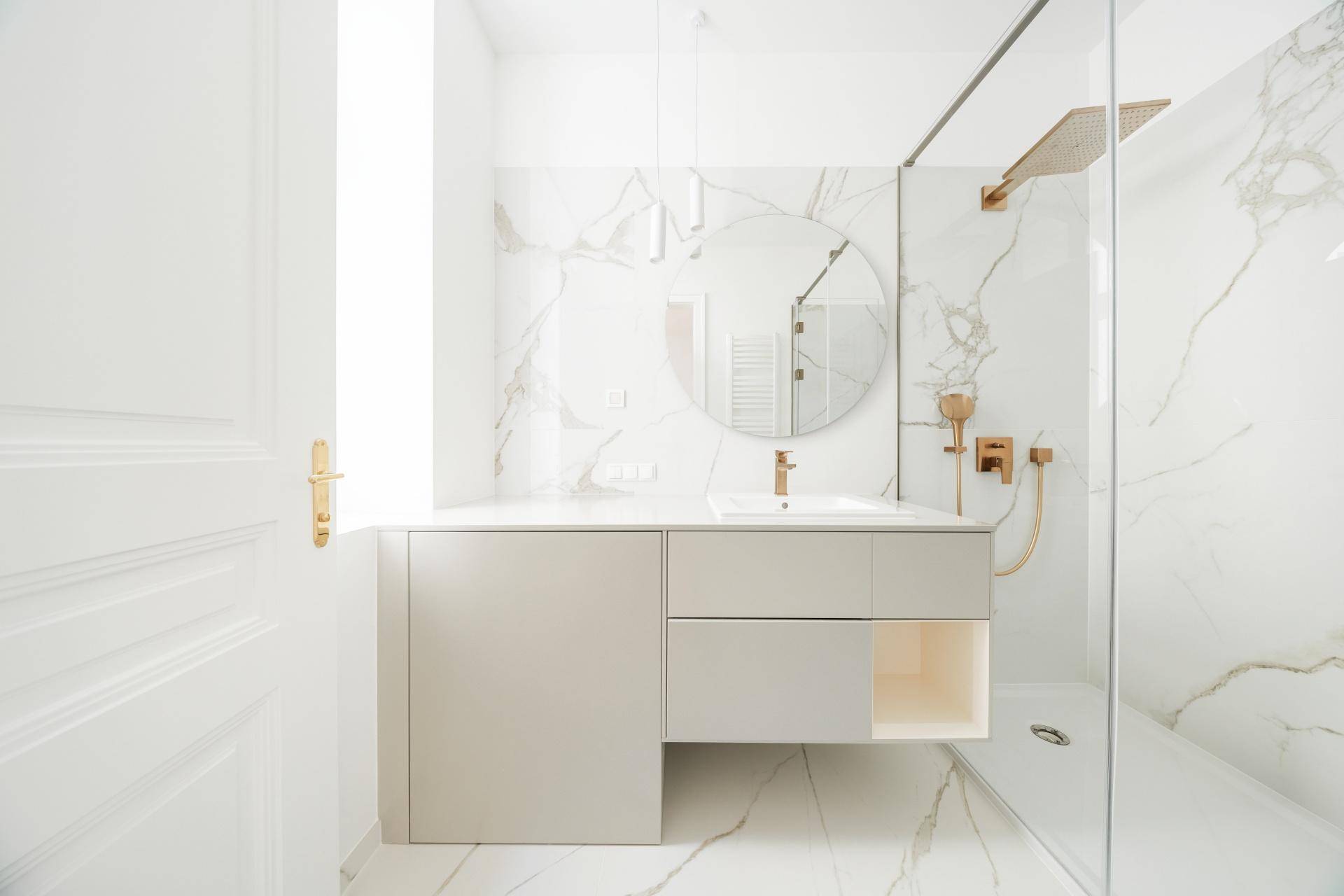Modernes Badezimmer mit Marmorfliesen, Einzelwaschbecken und begehbarer Dusche.