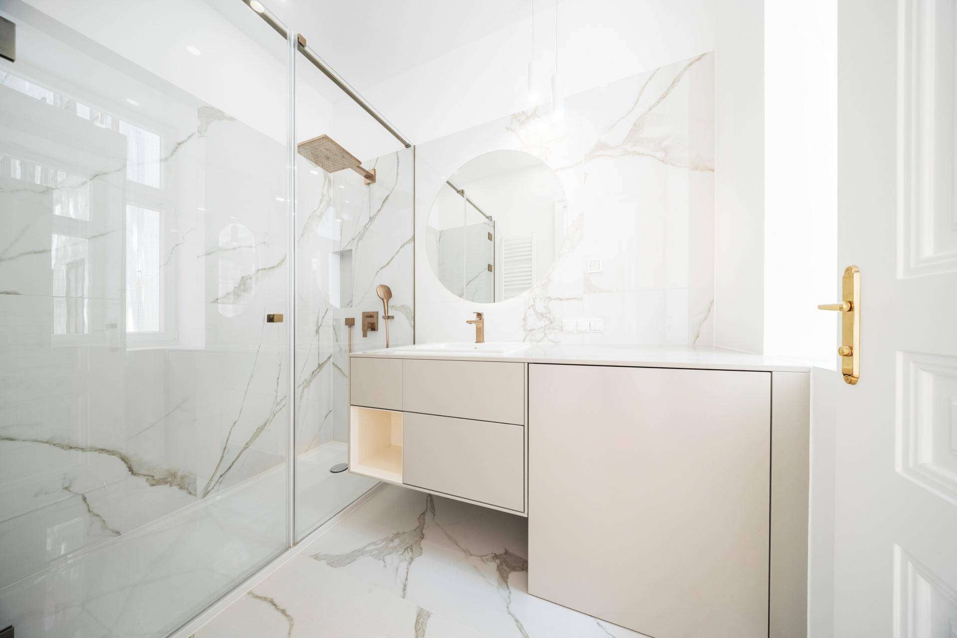 Modernes Badezimmer mit Marmorfliesen, begehbarer Dusche und elegantem Waschtisch.