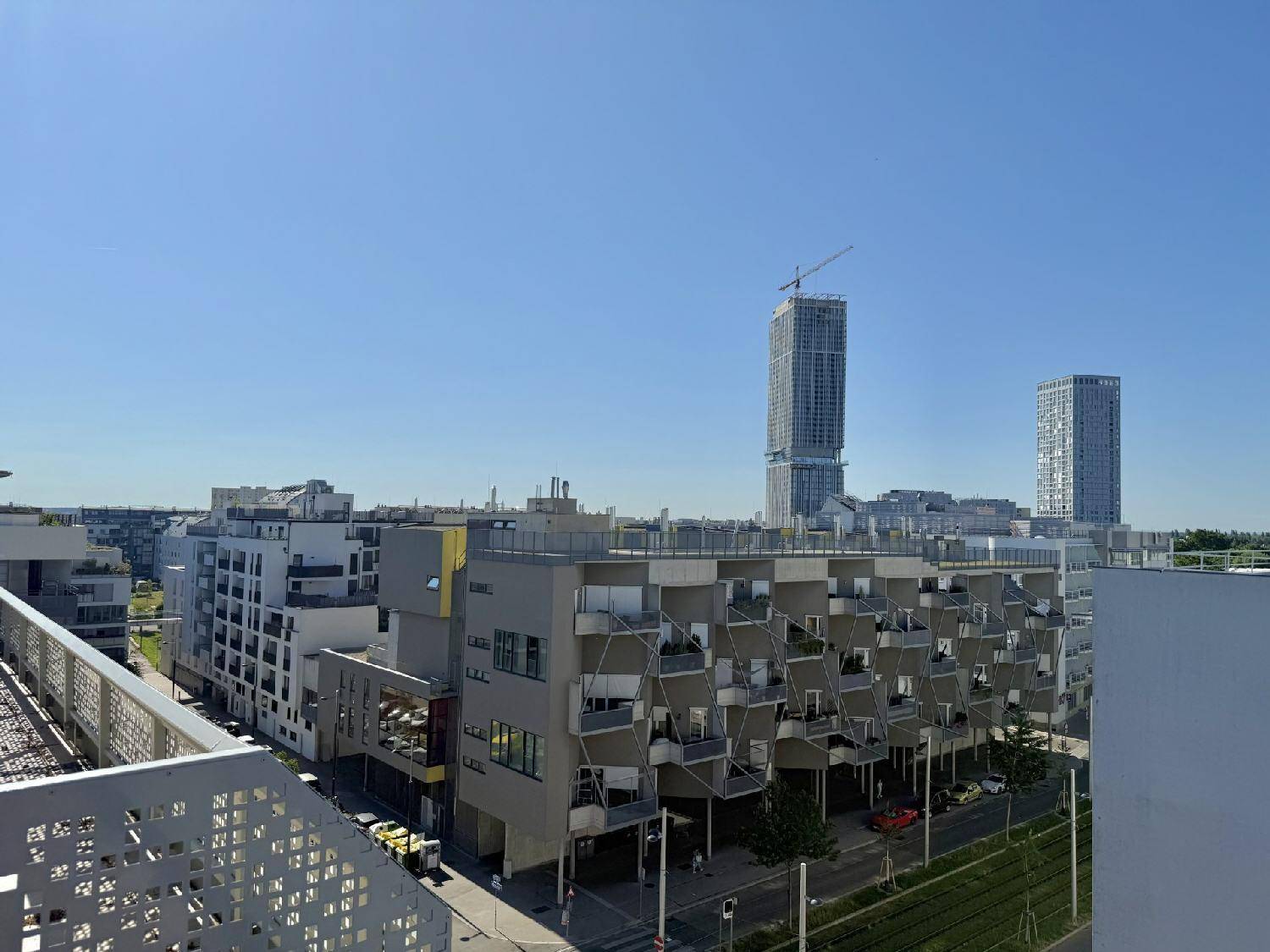 Weitläufiger Blick über eine moderne Stadtlandschaft mit Hochhäusern und Wohngebäuden.