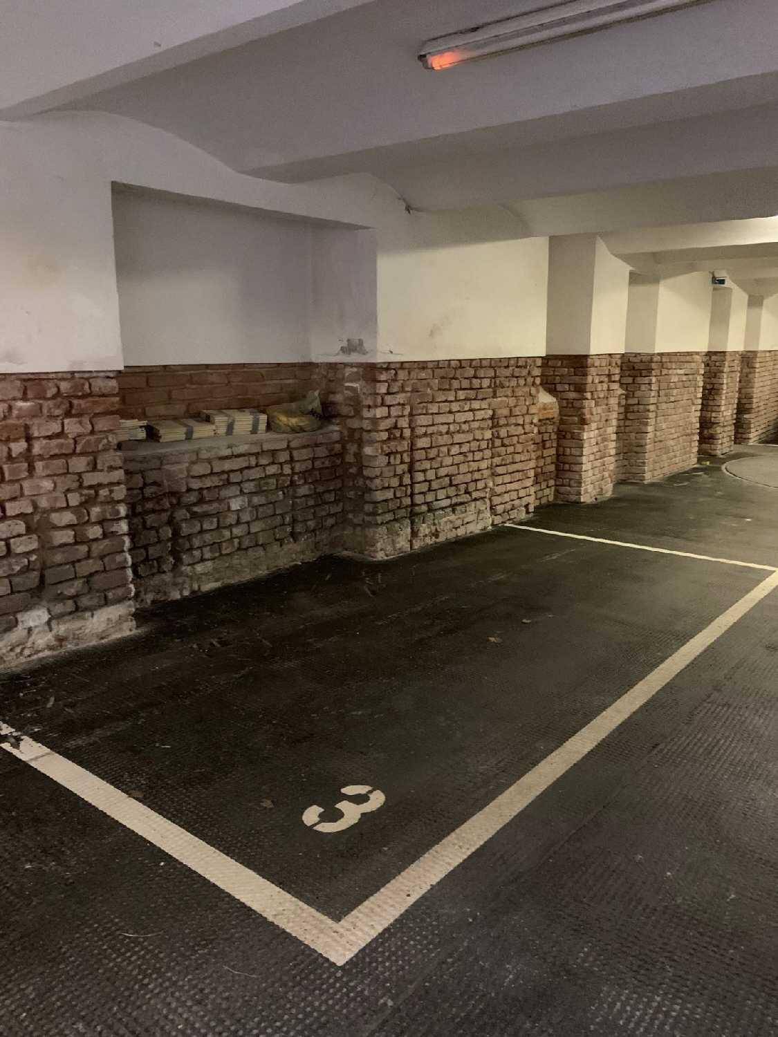 Tiefgaragenstellplatz Nummer 3 mit sichtbaren Ziegelwänden und einfacher Beleuchtung.