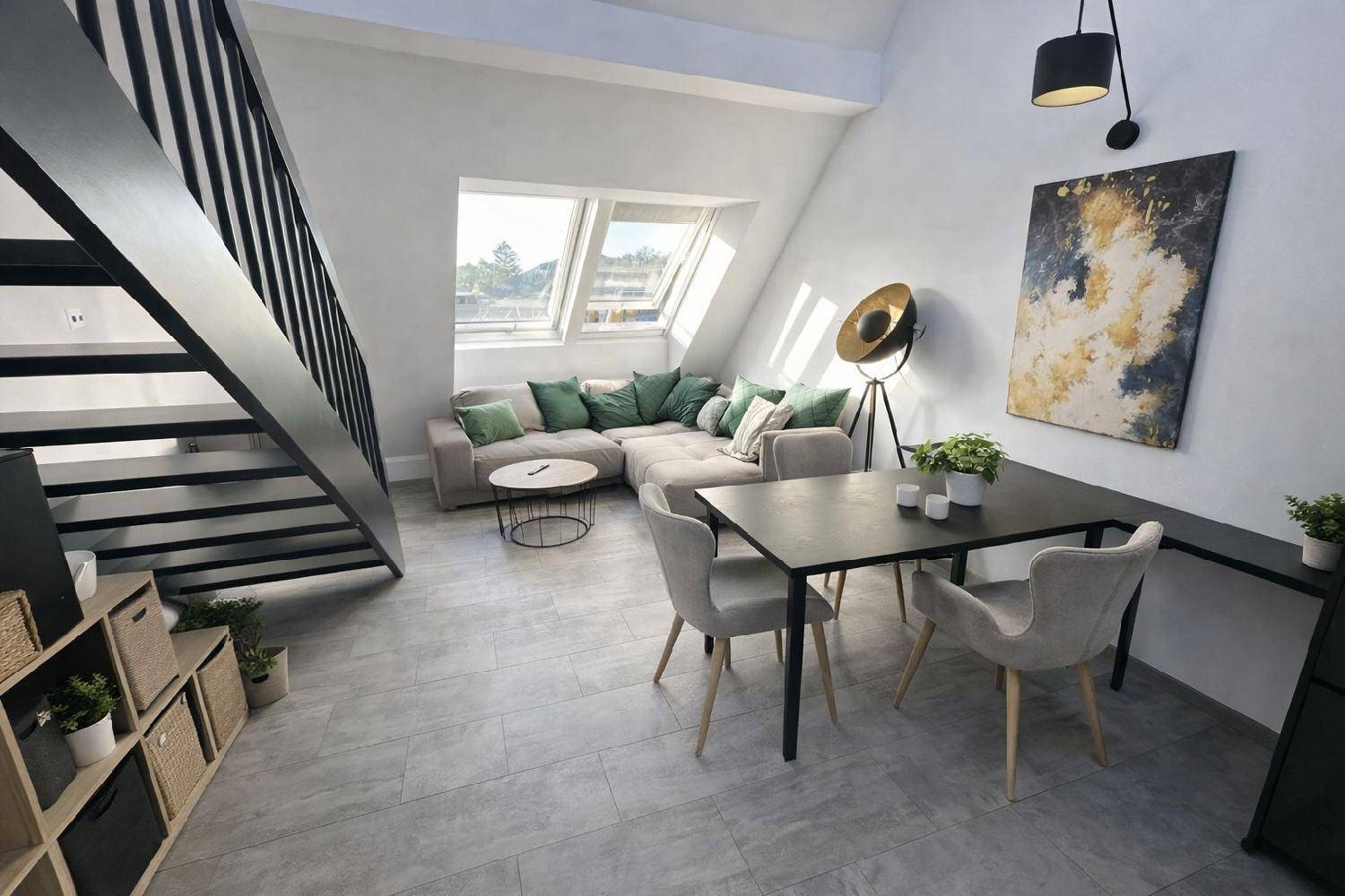 Heller Wohn- und Essbereich mit gemütlicher Sitzecke, Dachfenstern und Zugang zur oberen Etage.
