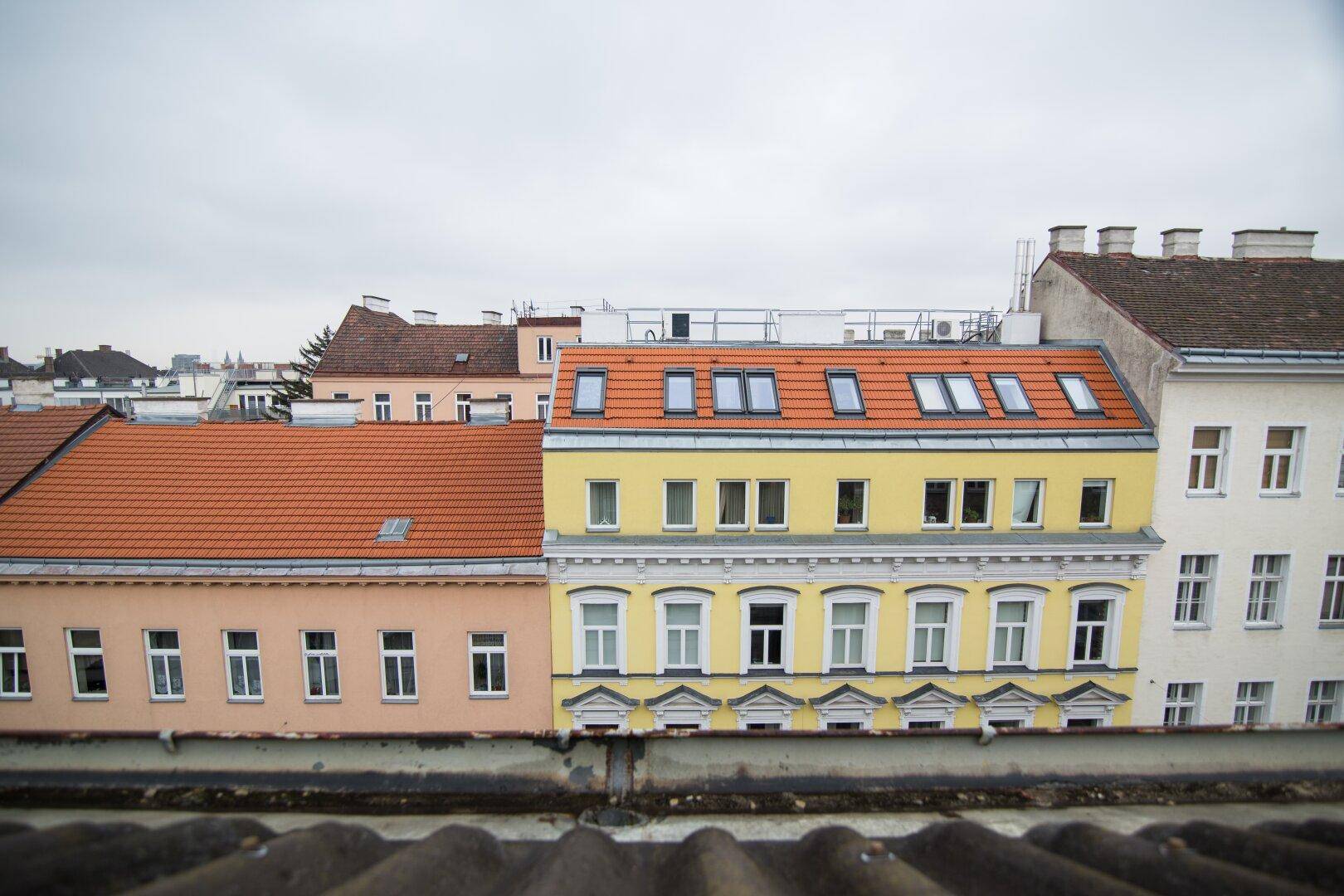 Panoramablick über die Dächer der Stadt mit historischen und modernen Gebäuden.