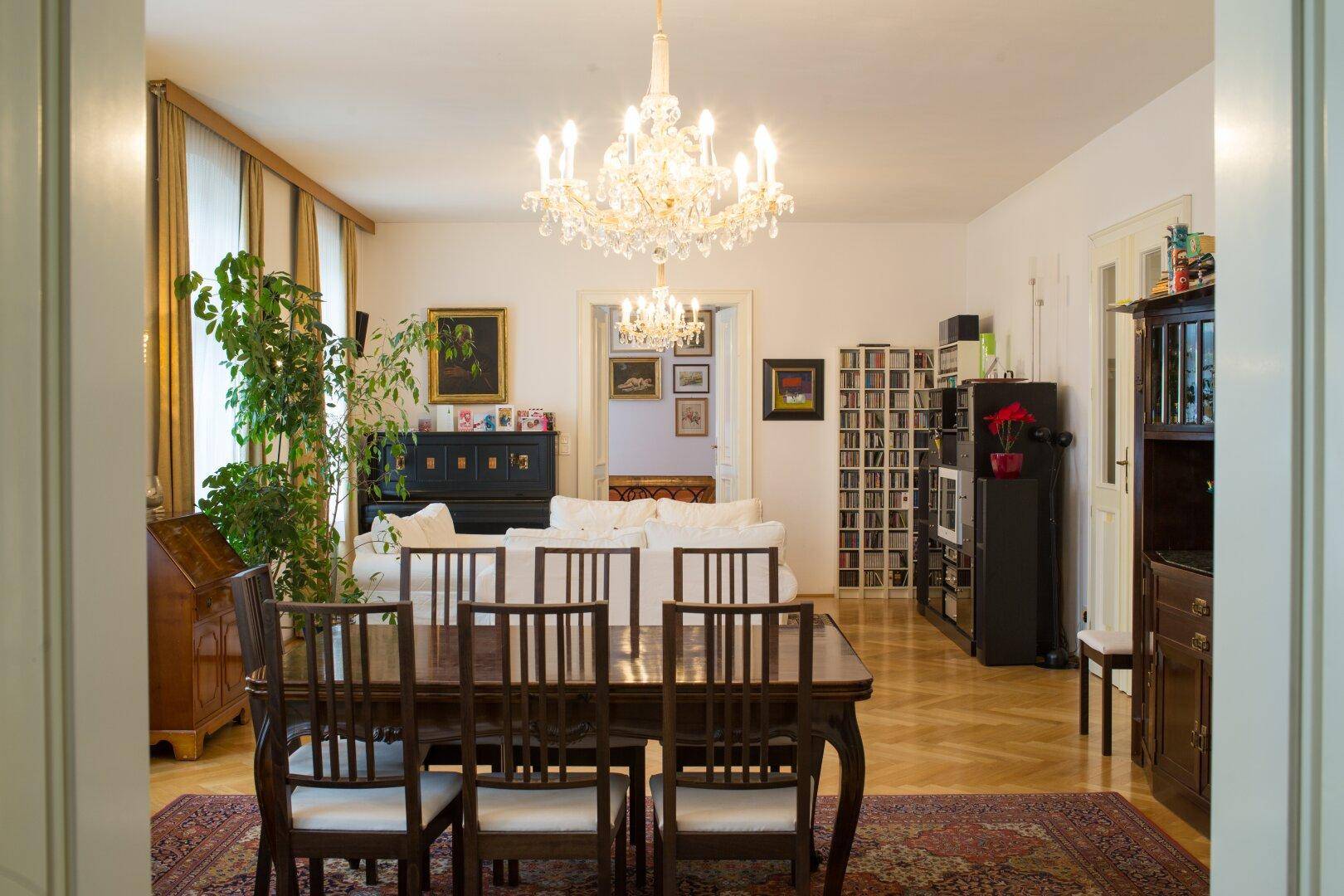 Elegantes Wohn- und Esszimmer mit Kronleuchter, Parkettboden und klassischer Einrichtung, hell und geräumig.