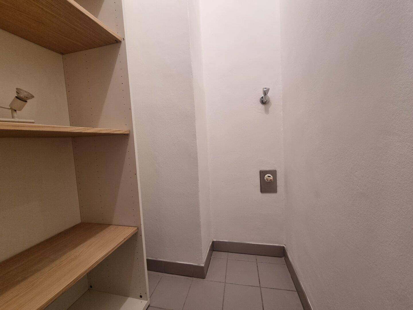 Praktischer Abstellraum mit Regalen und gefliestem Boden, bietet zusätzlichen Stauraum.