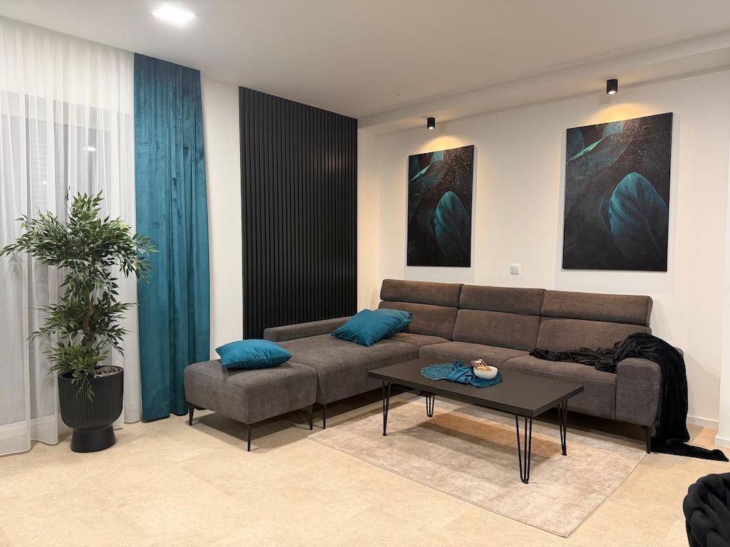 Gemütlicher Wohnbereich mit großem Ecksofa, dekorativen Kissen und stilvollen Wandbildern.