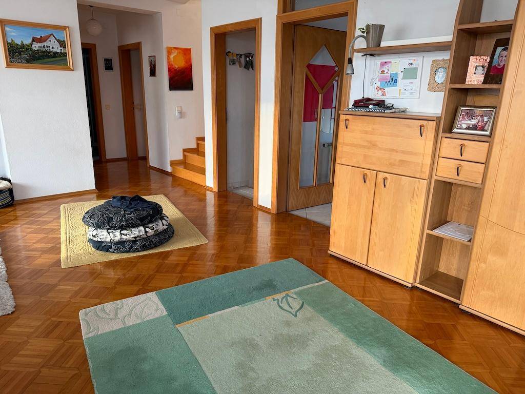 Offener Wohn- und Essbereich mit Parkettboden und traditionellen Holzmöbeln.