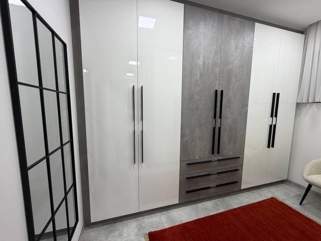 Funktionaler begehbarer Kleiderschrank mit modernen Schränken in Weiß und Grau, ideal für Organisation.