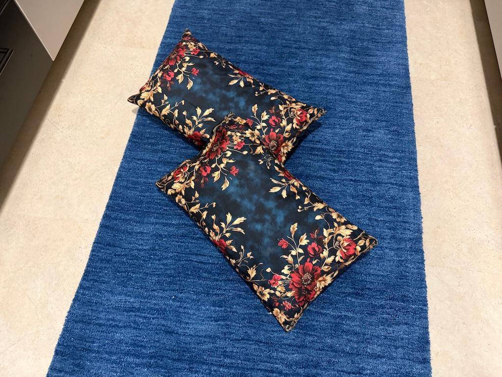 Detailansicht eines blauen Teppichs mit dekorativen Kissen im Schlafzimmer.