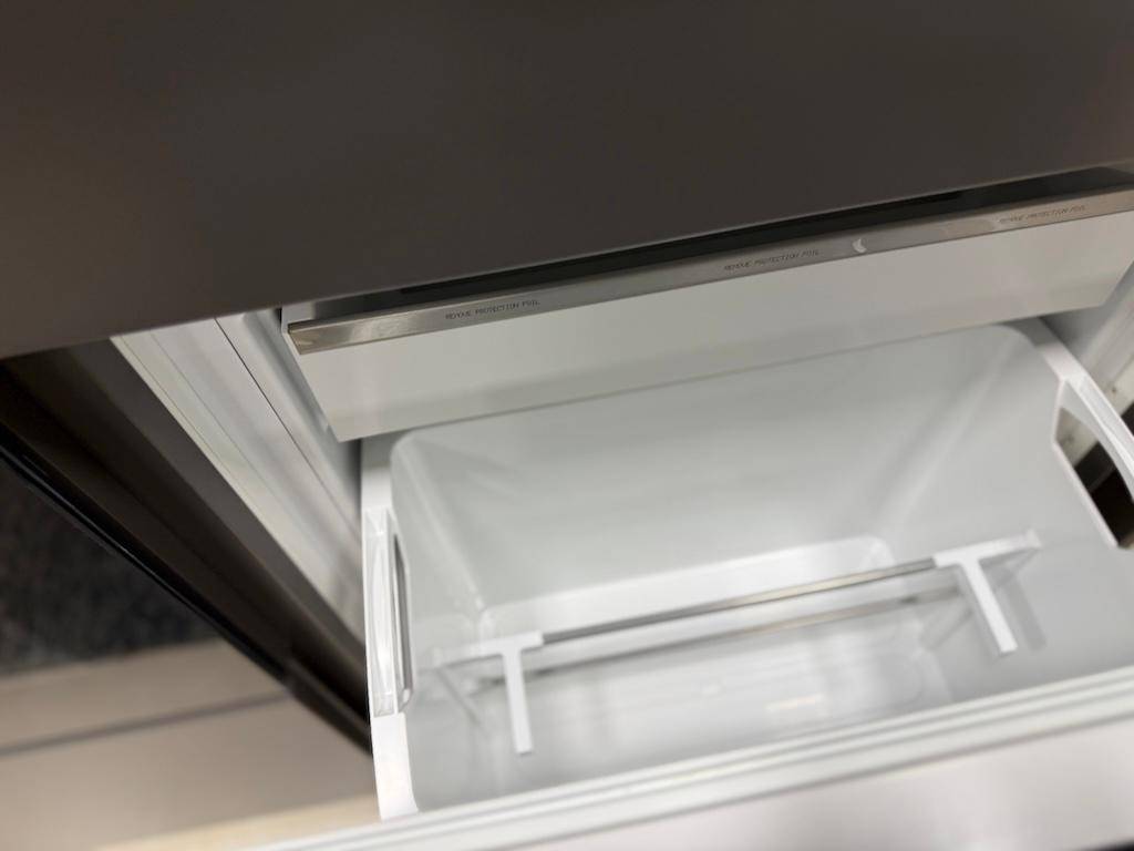 Detailansicht eines leeren Kühlschrankfachs mit sauberer, moderner Innenausstattung.