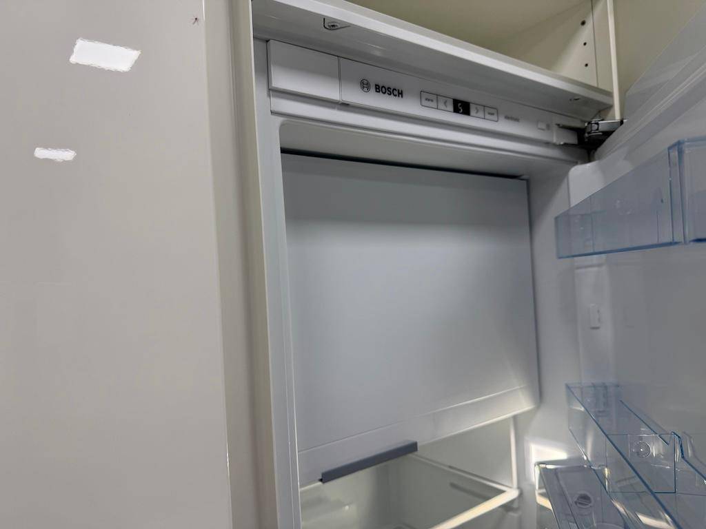 Offener Kühlschrank der Marke Bosch mit sauberem Innenraum und praktischen Fächern.