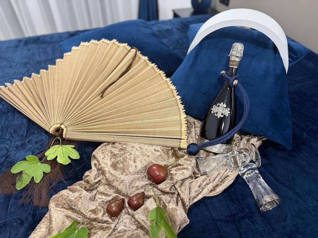 Dekorative Elemente auf einem blauen Samtbett, die eine luxuriöse und gemütliche Atmosphäre schaffen.