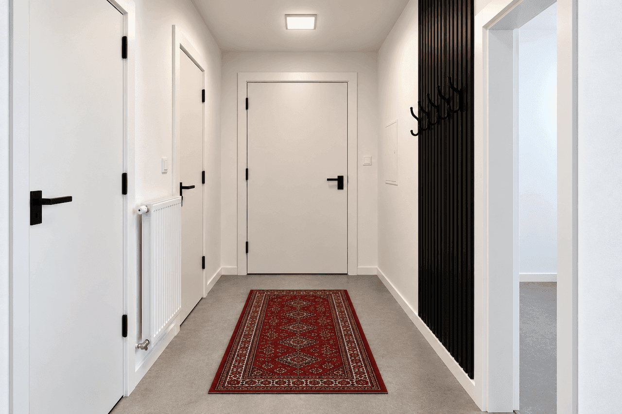 Eingangsbereich mit Garderobe, Heizkörper und Zugang zu weiteren Räumen.