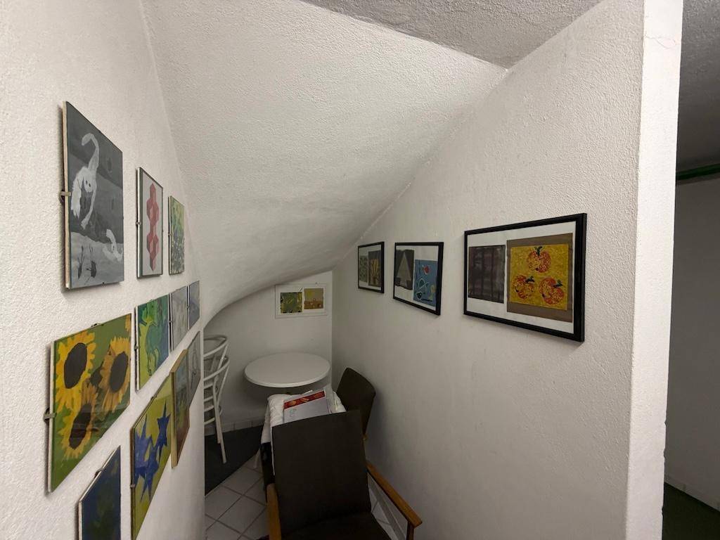 Gemütliche Sitzecke unter einer Dachschräge im Keller, dekoriert mit Bildern.