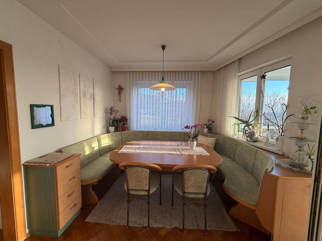Heller Essbereich mit traditioneller Eckbank, Holztisch und Fenster mit Ausblick.