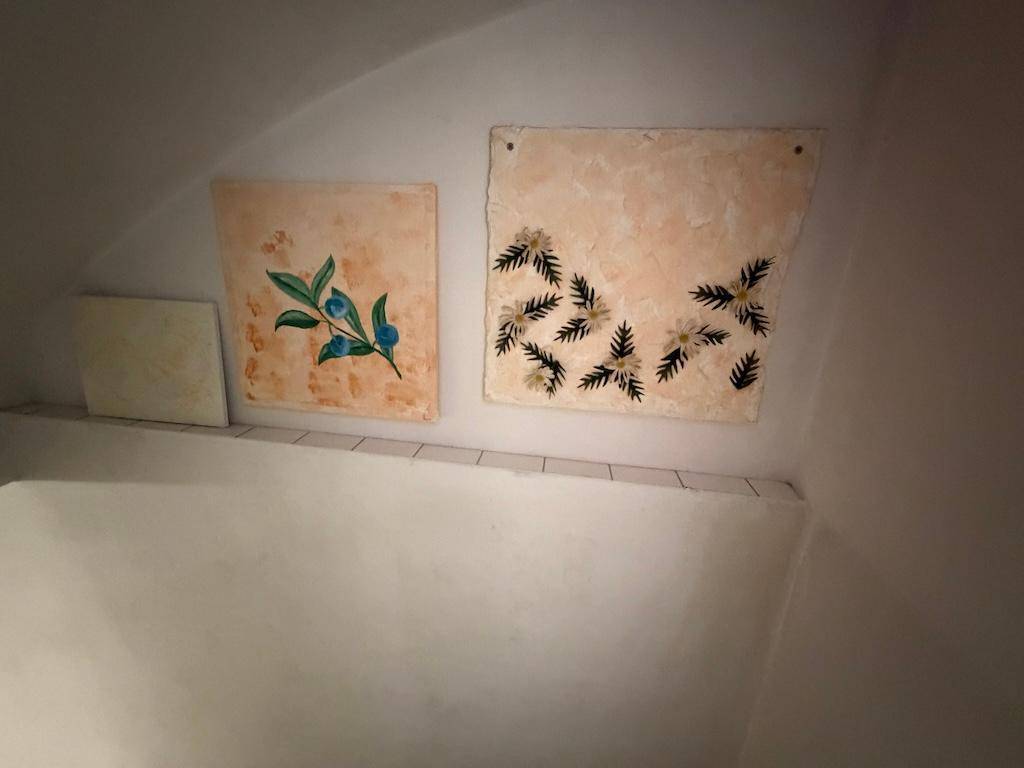 Zwei dekorative Wandbilder mit floralen Motiven an einer hellen Wand.