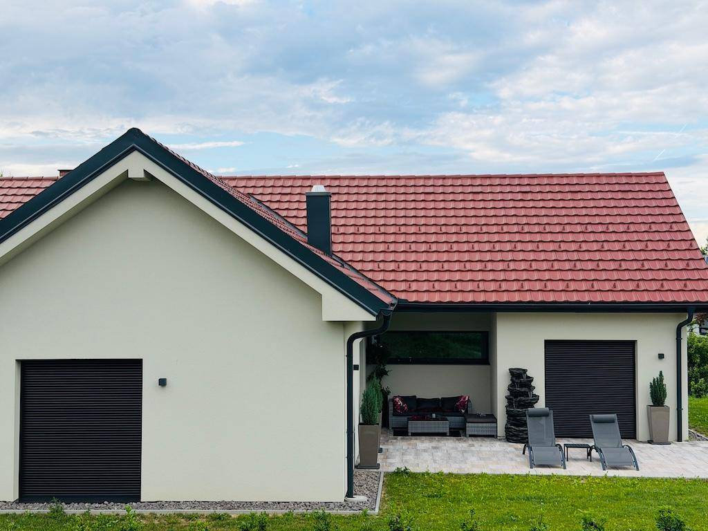 Überdachte Terrasse mit Lounge-Möbeln und einem dekorativen Wasserfall, ideal zum Entspannen.