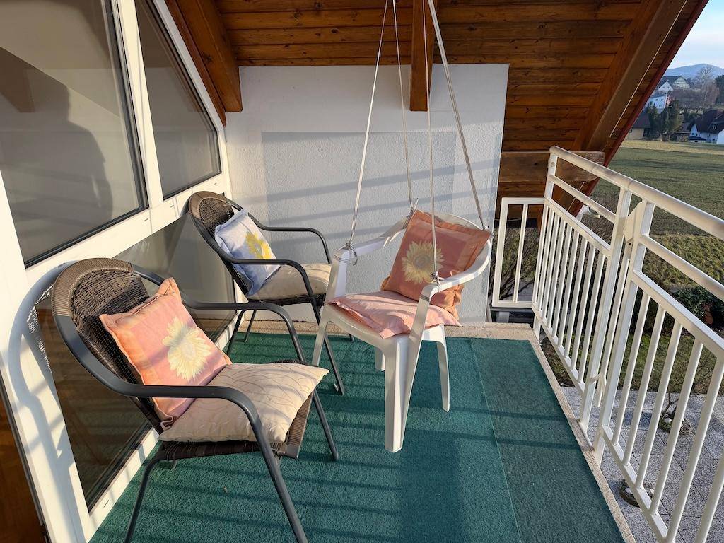 Gemütlicher Balkon mit Sitzgelegenheiten und weitem Blick über die Landschaft.