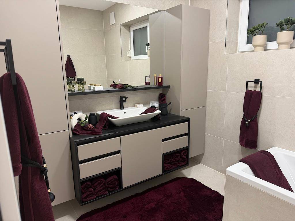Modernes Badezimmer mit großem Waschtisch, Spiegel und Badewanne.