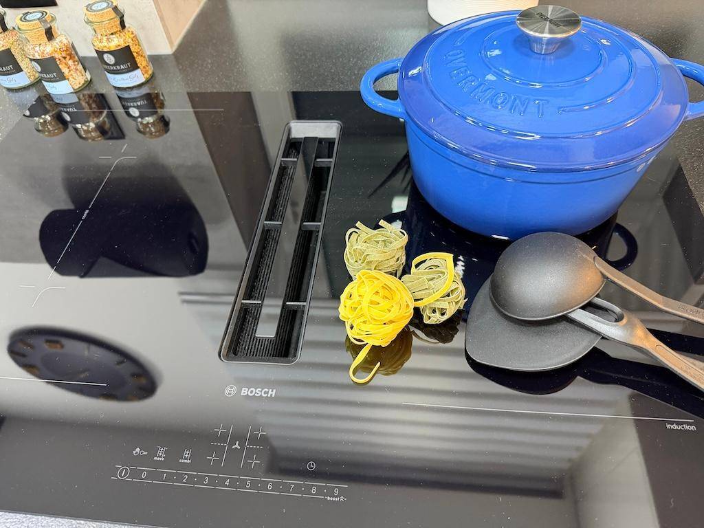 Bosch Induktionskochfeld mit integriertem Abzug, bereit zum Kochen mit einem blauen Topf.