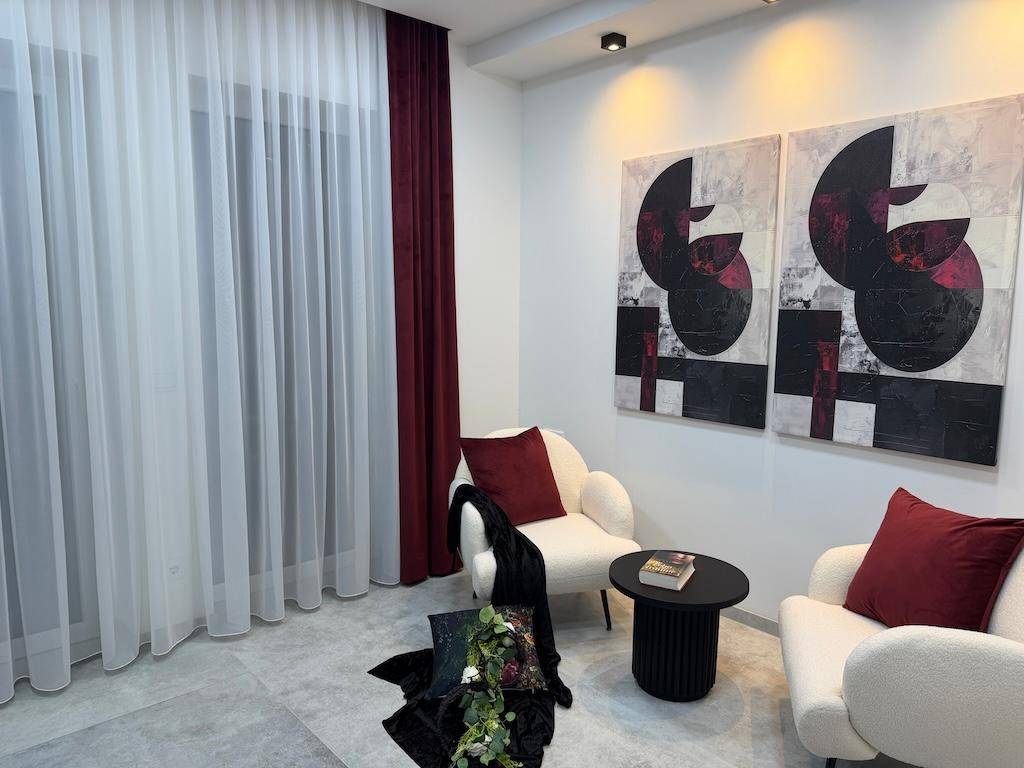 Gemütliche Sitzecke mit zwei modernen Sesseln, Beistelltisch und abstrakten Kunstwerken an der Wand.
