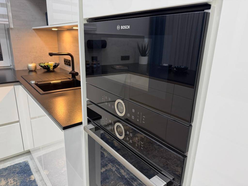 Integrierter Bosch Backofen und Mikrowelle in einer modernen, weißen Einbauküche.