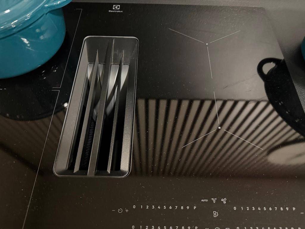 Moderne Induktionskochplatte mit integriertem Dunstabzugssystem in einer schwarzen Arbeitsplatte.