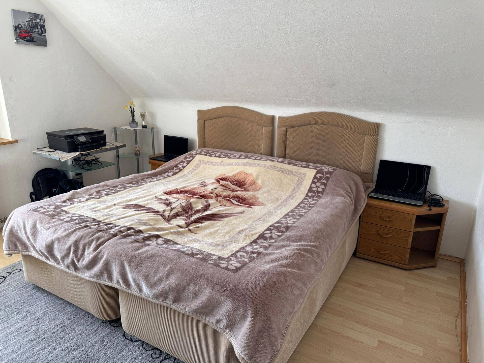 Schlafzimmer im Dachgeschoss mit Doppelbett, Nachttischen und einem Fenster.