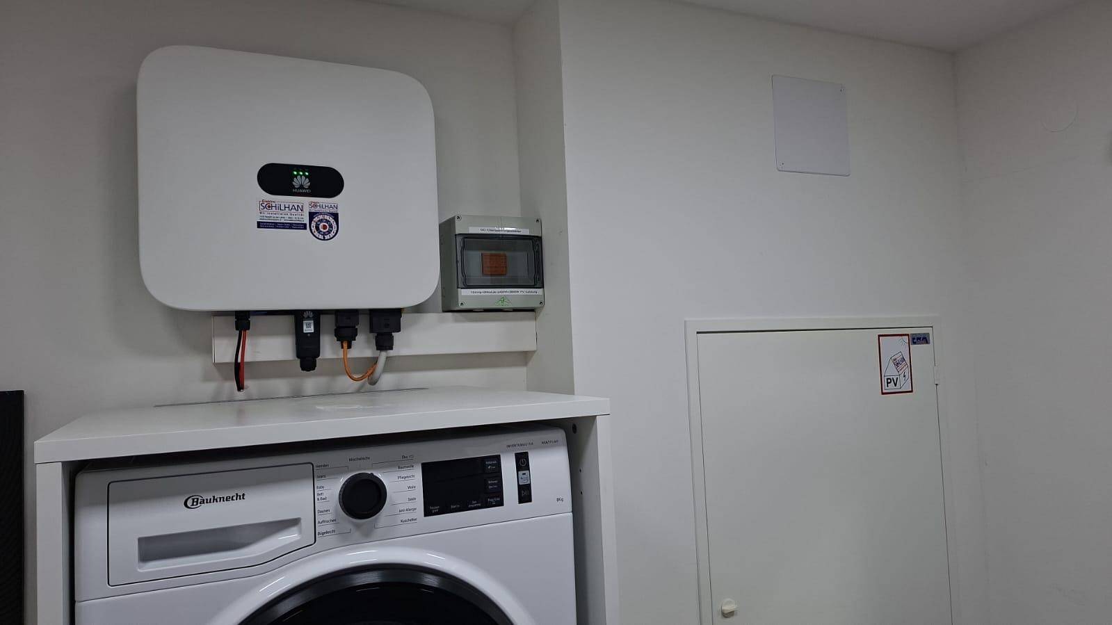 Hauswirtschaftsraum mit Waschmaschine und Photovoltaik-Wechselrichter, effizient und platzsparend eingerichtet.