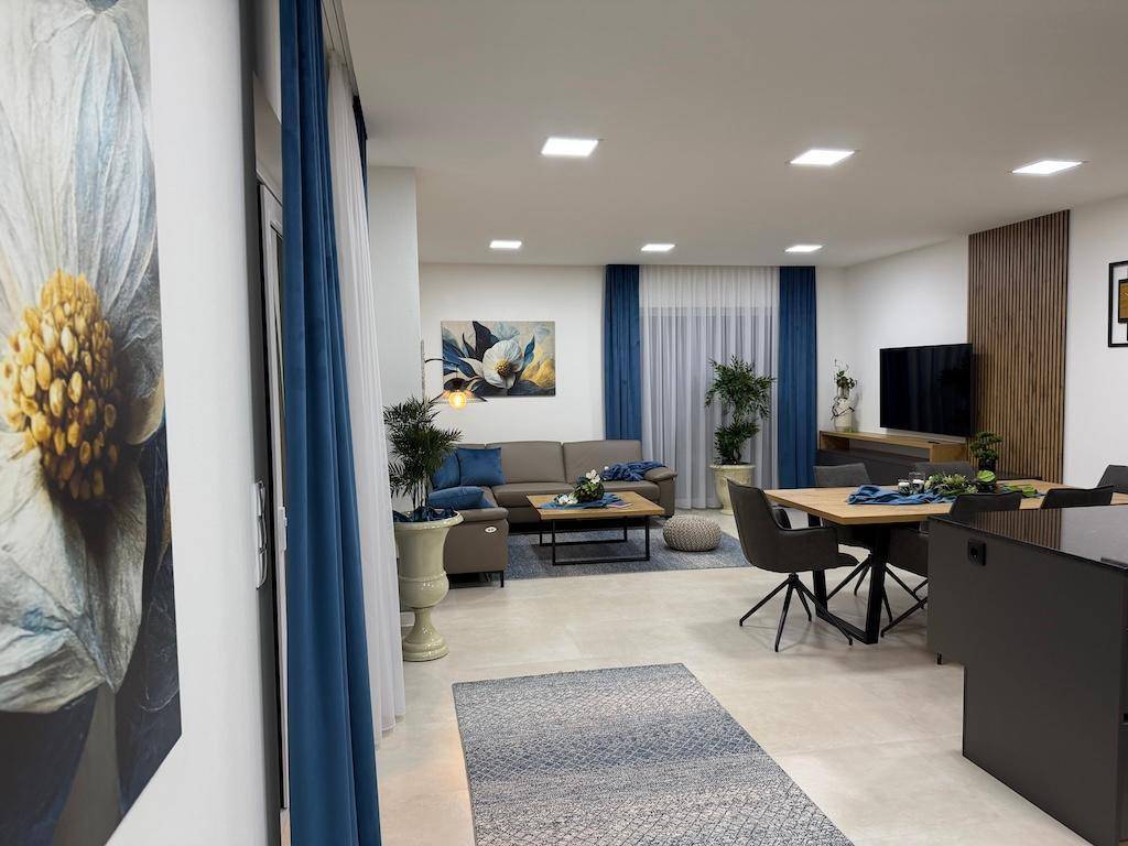 Geräumiger Wohn-Essbereich mit modernem Design, bequemen Sofas und einem großen Esstisch.
