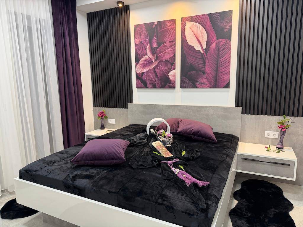 Helles Schlafzimmer mit großem Doppelbett, zwei Nachttischen und dekorativen Wandpaneelen.