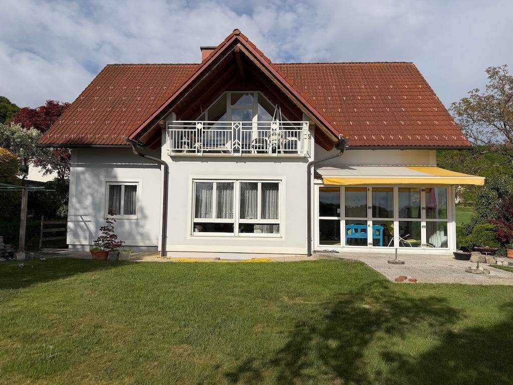 Freistehendes Haus mit Garten, Balkon und einem Wintergarten an der Seite.