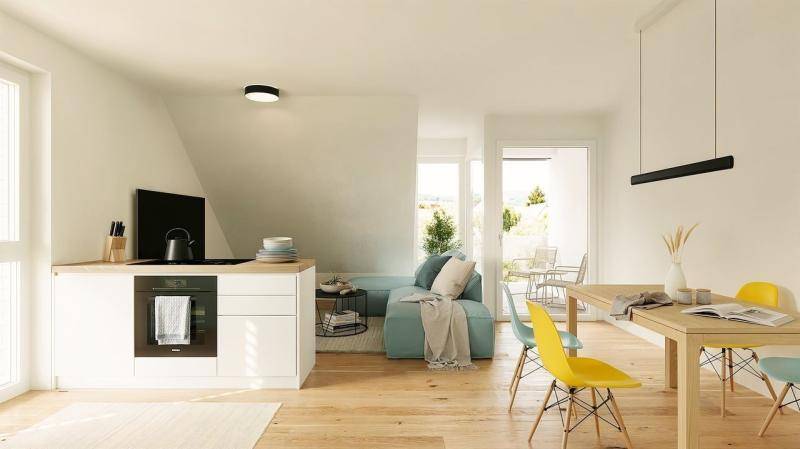 Heller, offener Wohn-Essbereich mit integrierter Küchenzeile, Holzboden und Zugang zum Balkon.