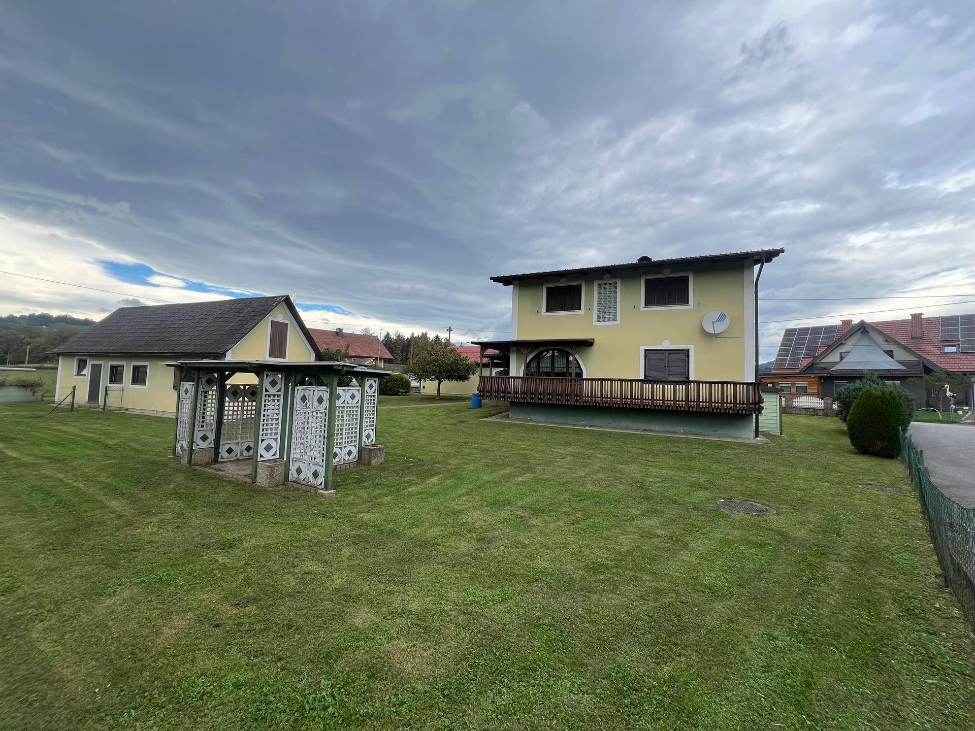 Weitläufiger Garten mit Rasen und einem charmanten Pavillon, umgeben von ländlicher Landschaft.