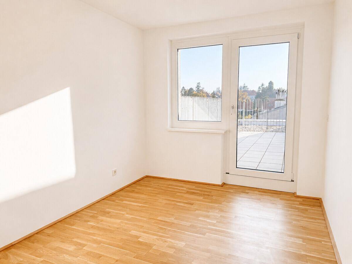Schlafzimmer mit Parkettboden und direktem Zugang zu einer Außenterrasse.