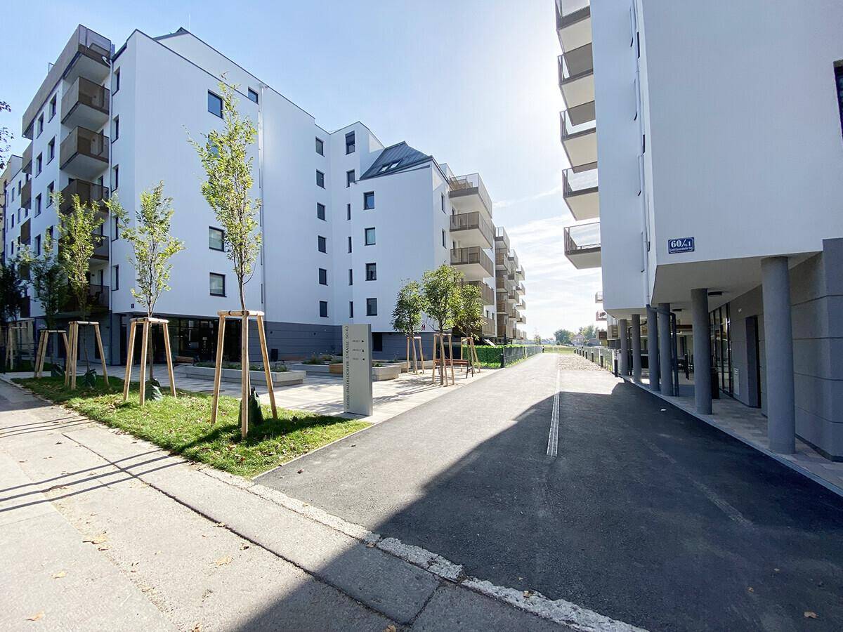Moderne Wohnanlage mit mehreren Gebäuden, Balkonen und gepflegten Außenbereichen.