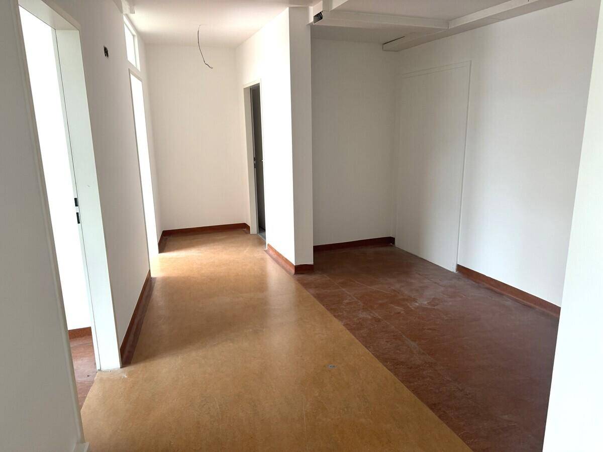 Geräumiger Flur mit hellem Boden und Zugang zu weiteren Räumen, ideal für ein Geschäft oder Büro.