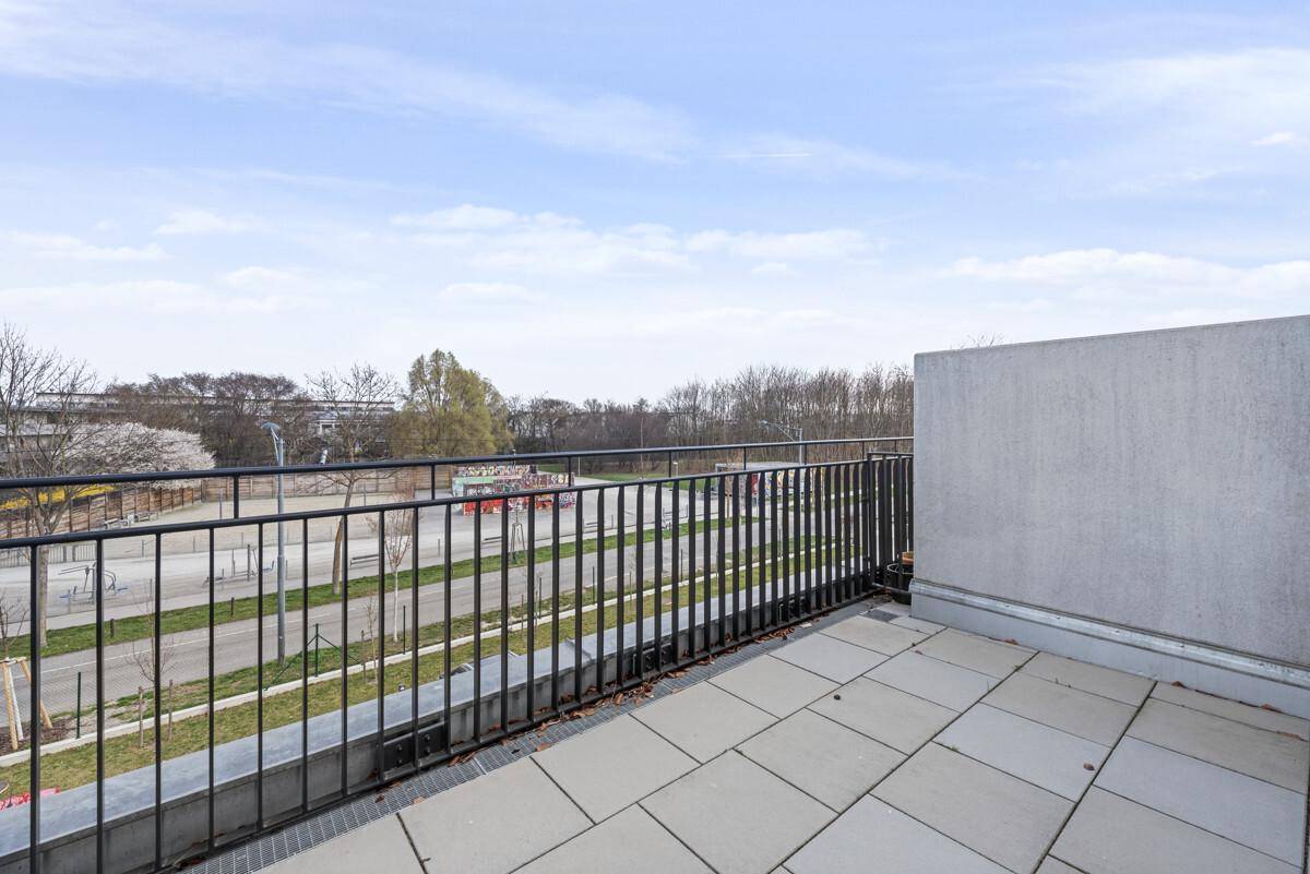 Großer Balkon mit Fliesenboden und Blick auf die Umgebung.