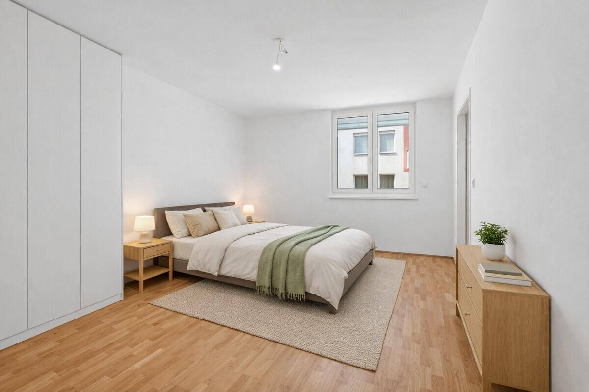 Modern eingerichtetes Schlafzimmer mit Doppelbett, Holzmöbeln und großem weißen Kleiderschrank.