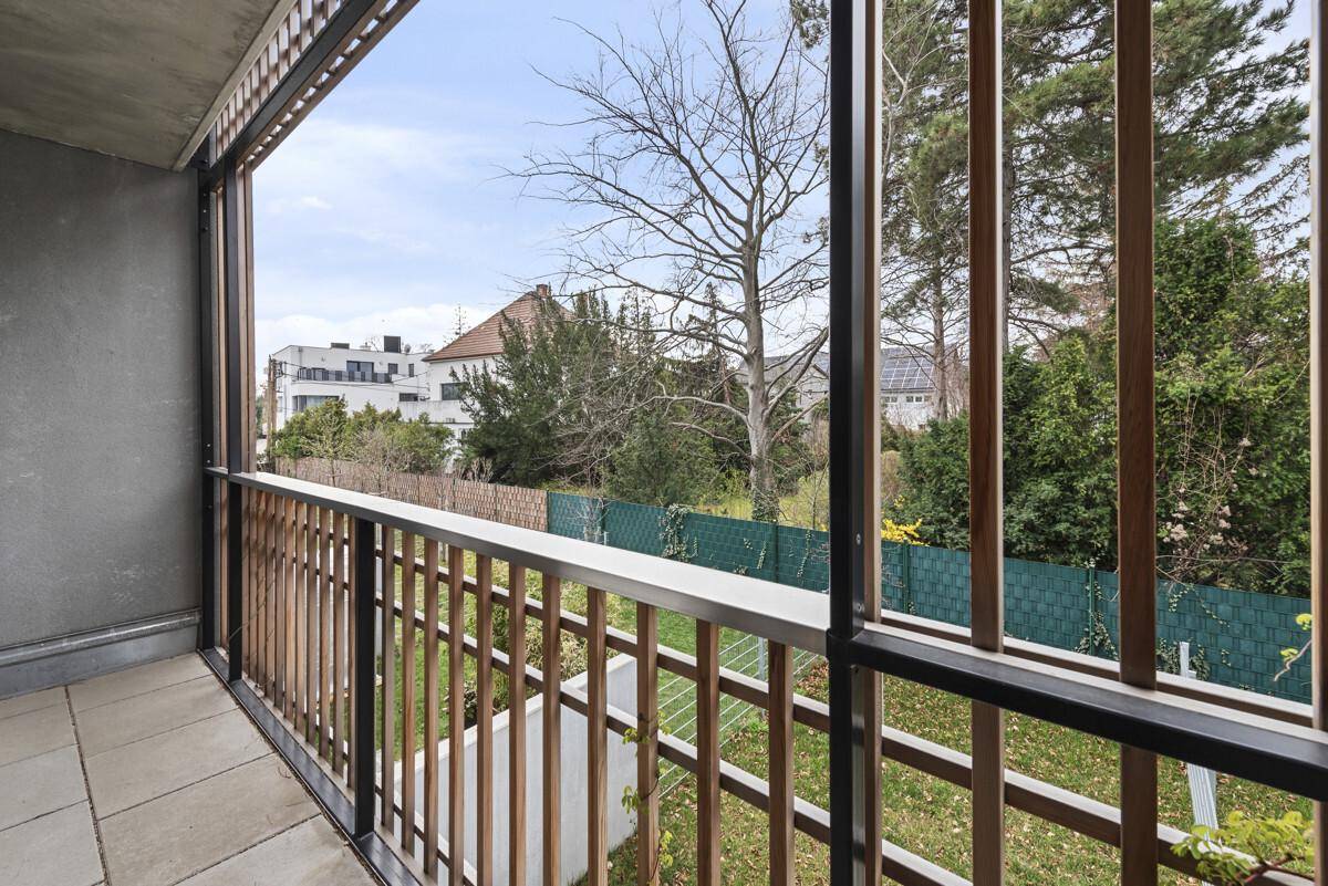 Balkon mit Holzelementen und Blick auf den Garten sowie die umliegende Wohngegend.