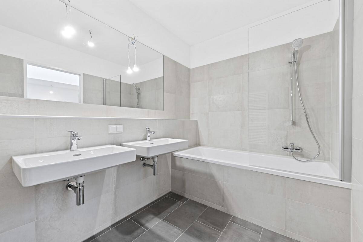 Modernes Badezimmer mit Doppelwaschbecken, Badewanne und Dusche.