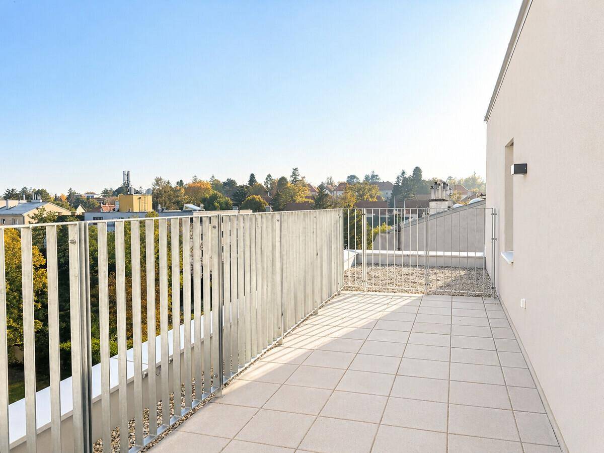Große, sonnige Dachterrasse mit Fliesenboden und weitem Blick über die Stadt.