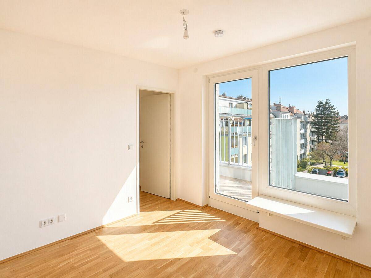Lichtdurchfluteter Raum mit Parkettboden und Fensterbank, bietet Zugang zu einem Außenbereich.