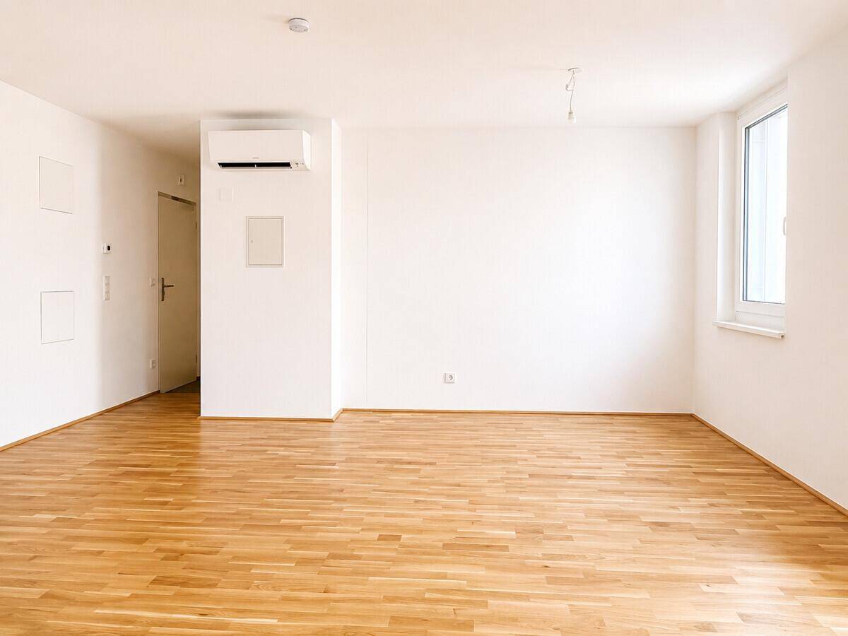 Heller Raum mit Parkettboden und Klimaanlage, ideal für ein Schlaf- oder Wohnzimmer.