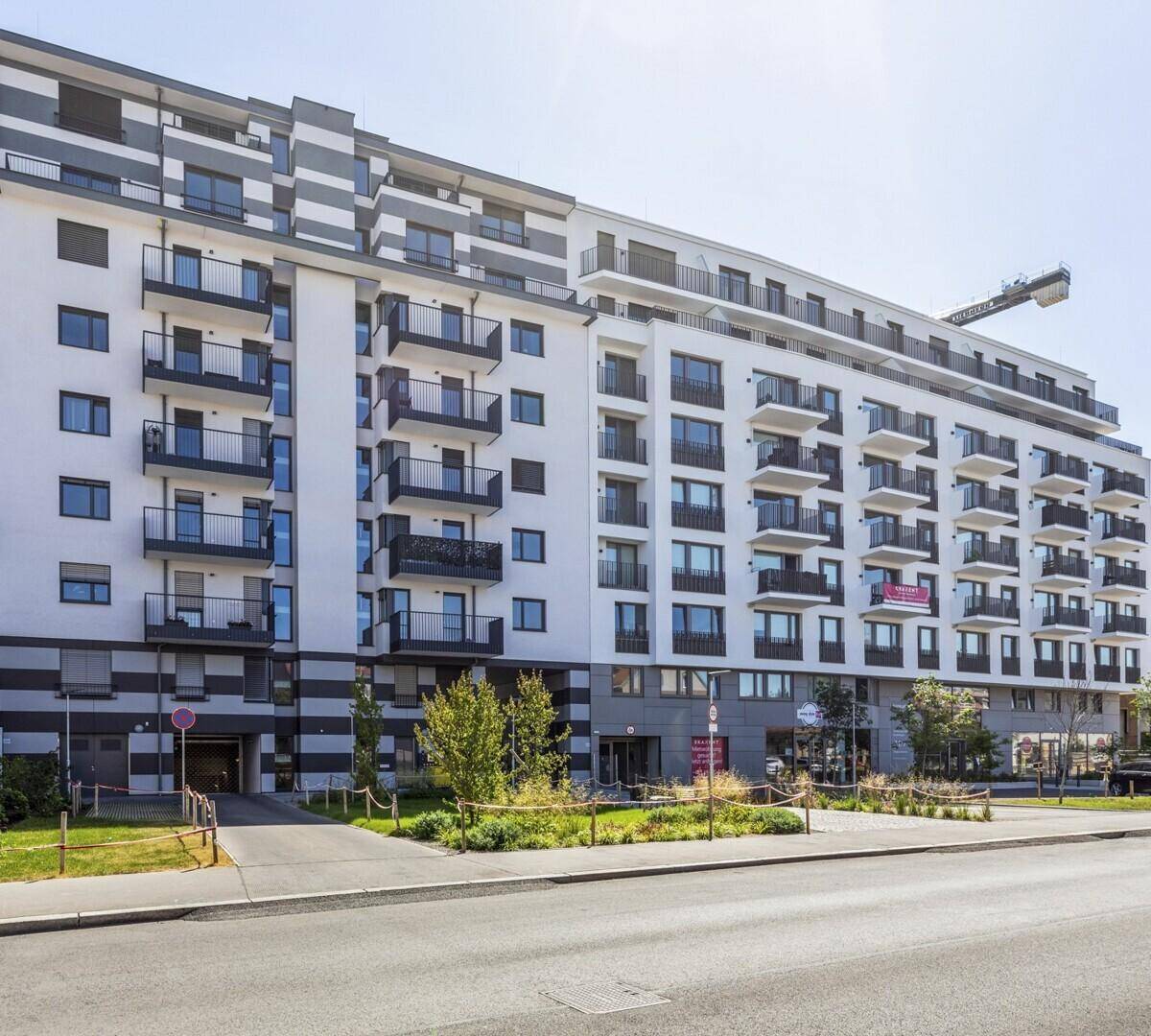 Modernes Mehrfamilienhaus mit vielen Balkonen und einer ansprechenden Fassadengestaltung.