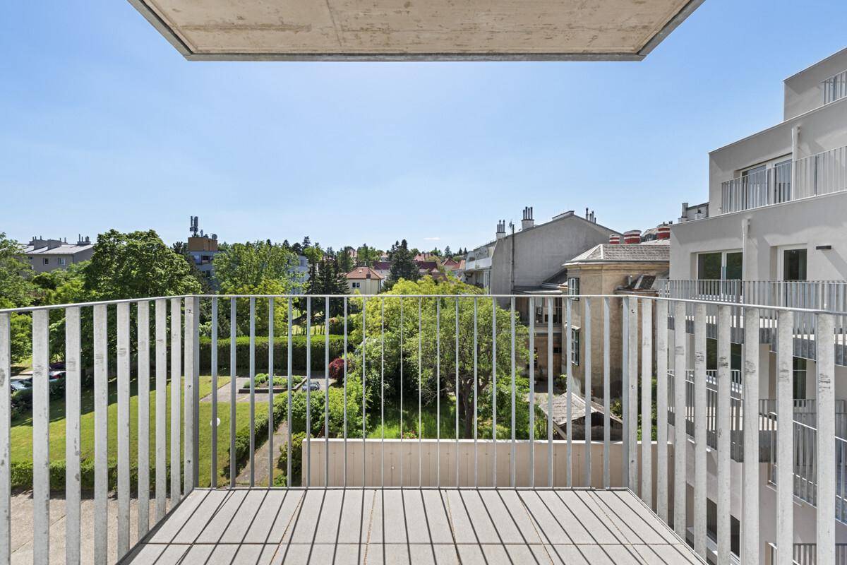 Heller Balkon mit Metallgeländer und Blick ins Grüne, ideal für entspannte Stunden im Freien.